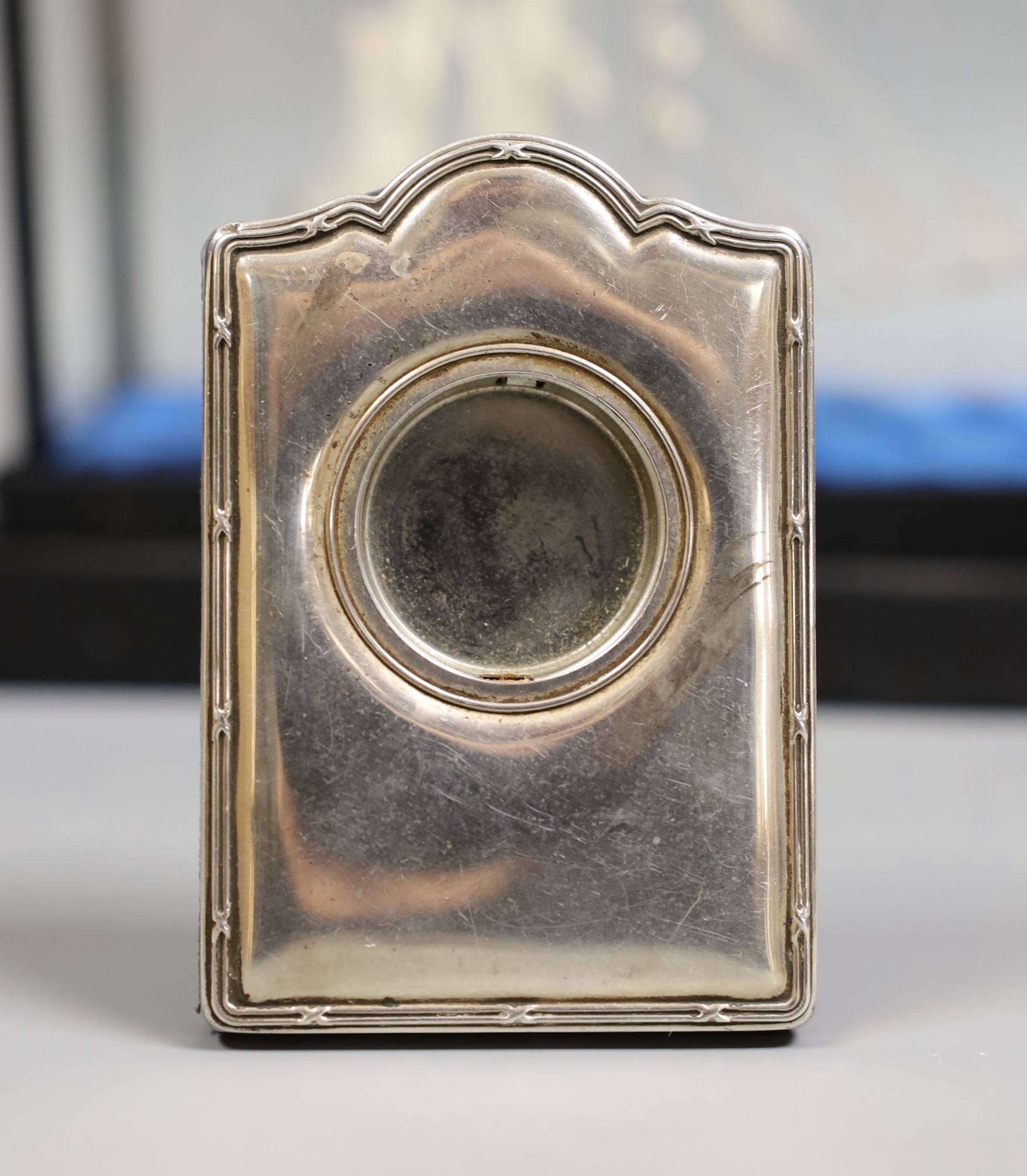 A group of silver and white metal items including a cased boat model, cigar cutter and mounted photograph frame and plated items